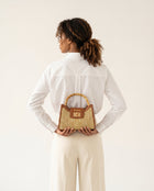 noribe bamboo handle handbag human carrying it.